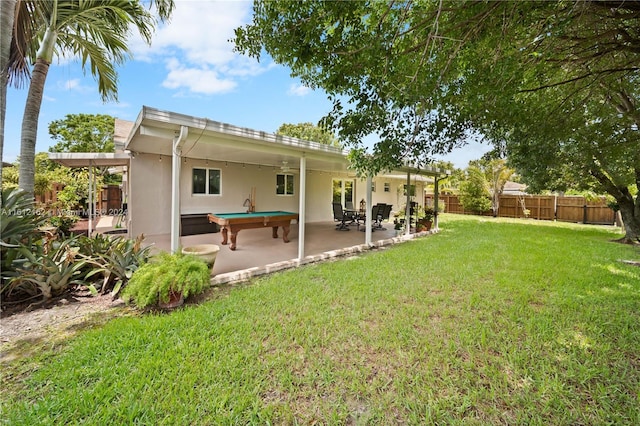 rear view of house with a lawn and a patio