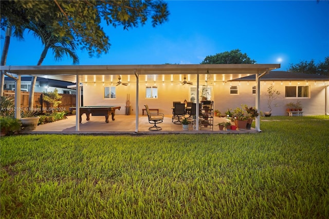 back of house with ceiling fan, a patio area, and a lawn