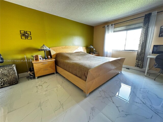 bedroom featuring a textured ceiling and tile floors