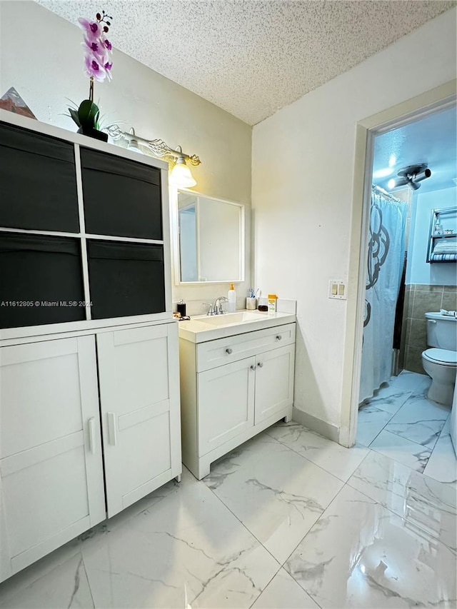 bathroom with tile flooring, oversized vanity, tile walls, a textured ceiling, and toilet