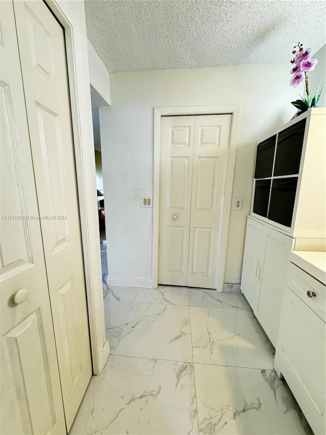 bathroom featuring tile floors and a textured ceiling