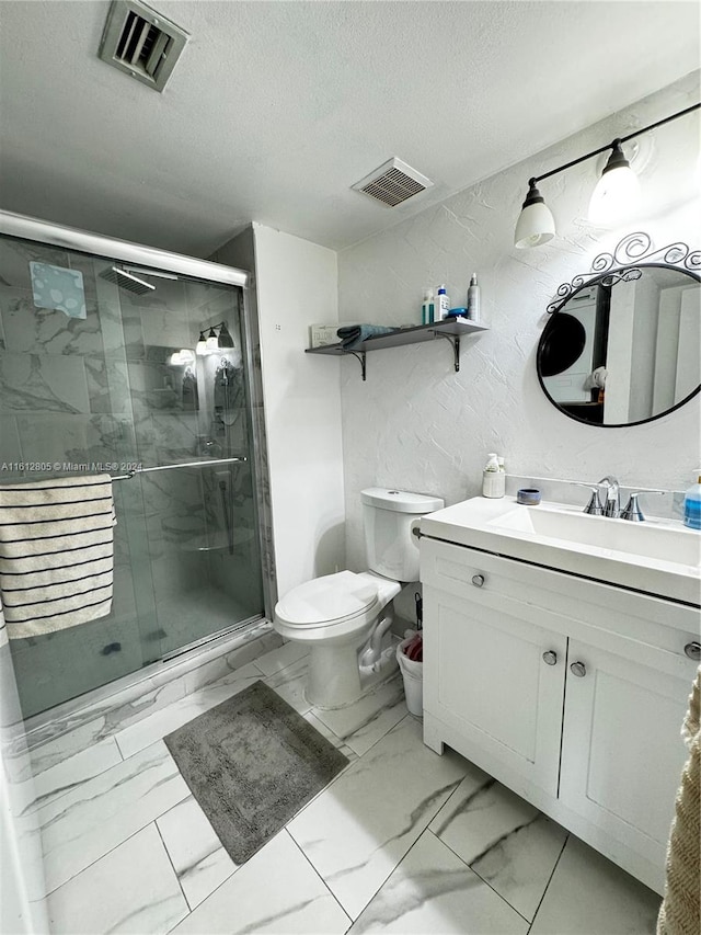 bathroom featuring a shower with door, a textured ceiling, tile floors, toilet, and large vanity