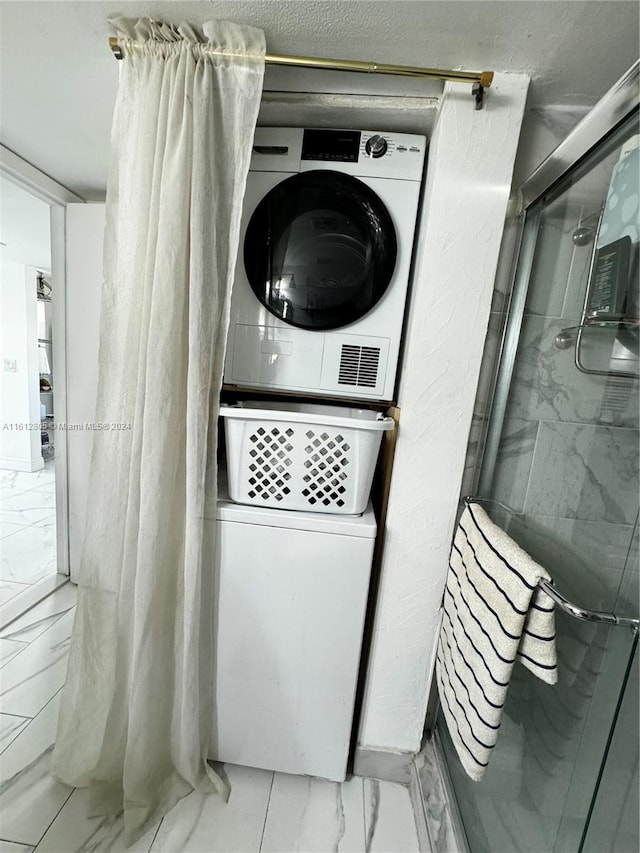 laundry room with stacked washing maching and dryer and tile flooring