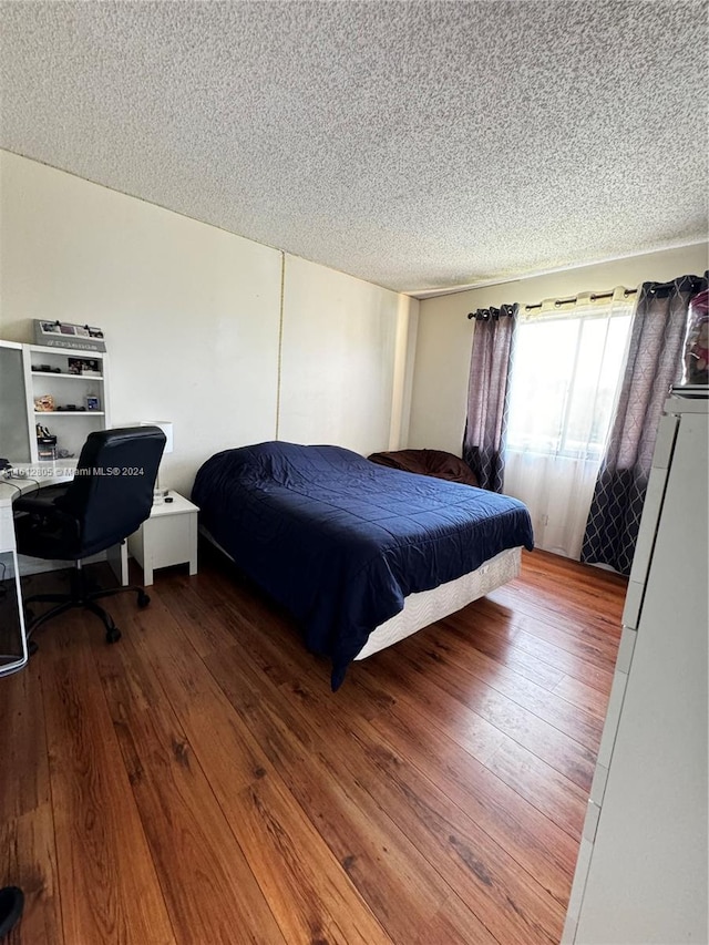 bedroom featuring hardwood / wood-style flooring and a textured ceiling