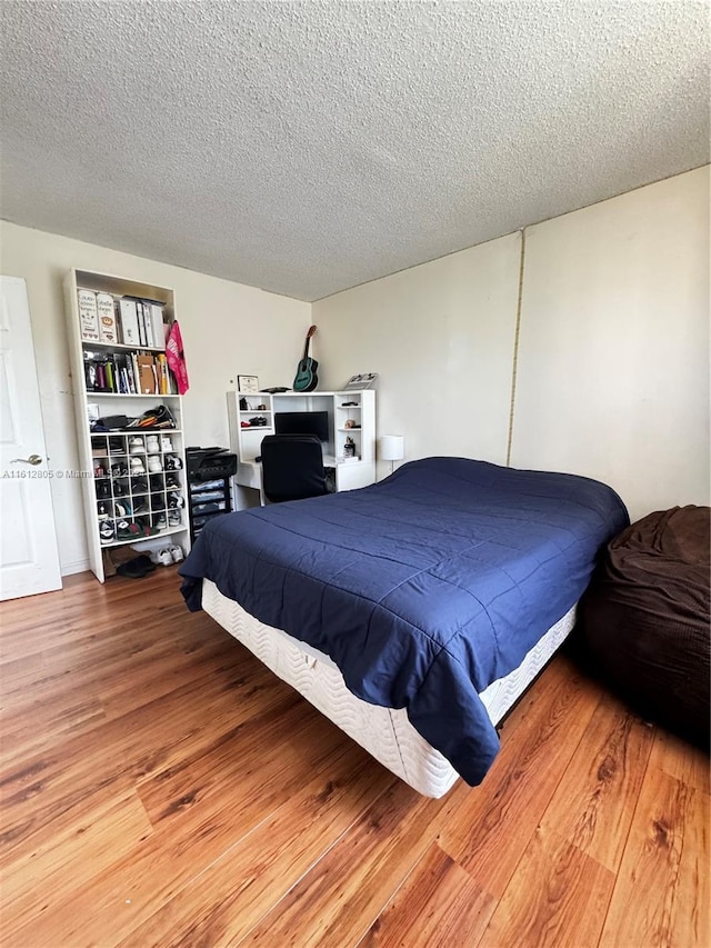 bedroom featuring a textured ceiling and hardwood / wood-style floors