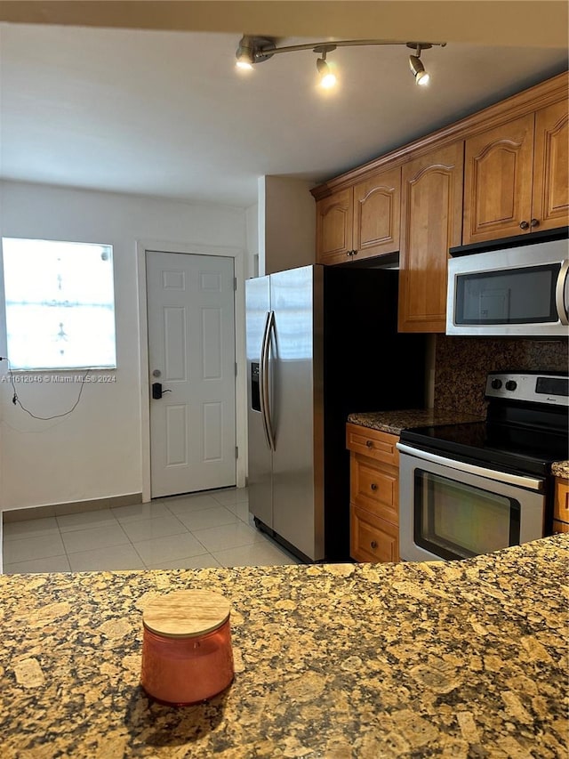 kitchen featuring light tile patterned floors, backsplash, and appliances with stainless steel finishes