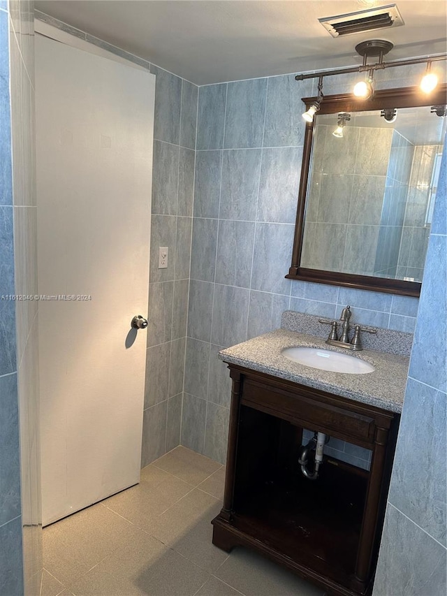 bathroom with vanity and tile walls