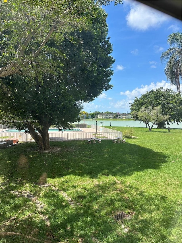 view of yard with a community pool and a water view