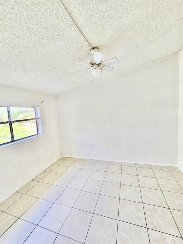 unfurnished room with ceiling fan, a textured ceiling, and light tile patterned floors