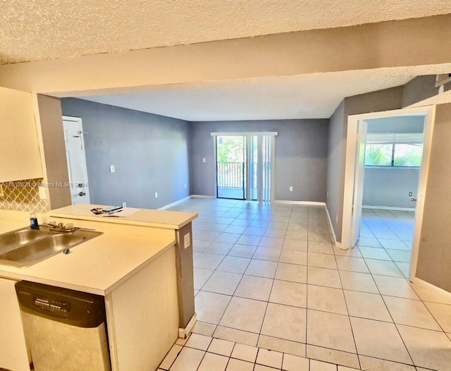 kitchen with dishwashing machine, tasteful backsplash, light tile patterned floors, a textured ceiling, and sink