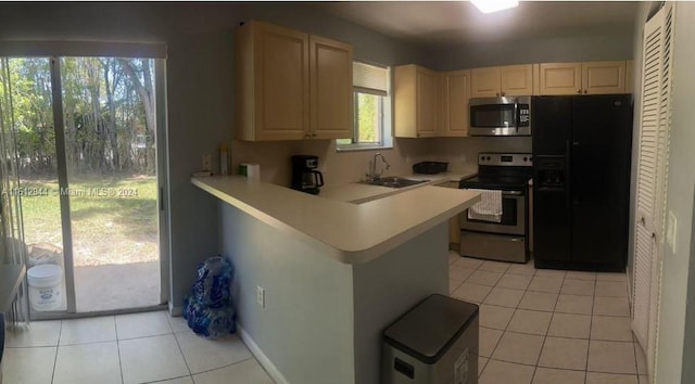 kitchen with sink, kitchen peninsula, stainless steel appliances, and light tile patterned floors