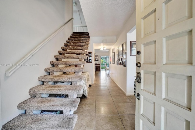 tiled entryway with a textured ceiling