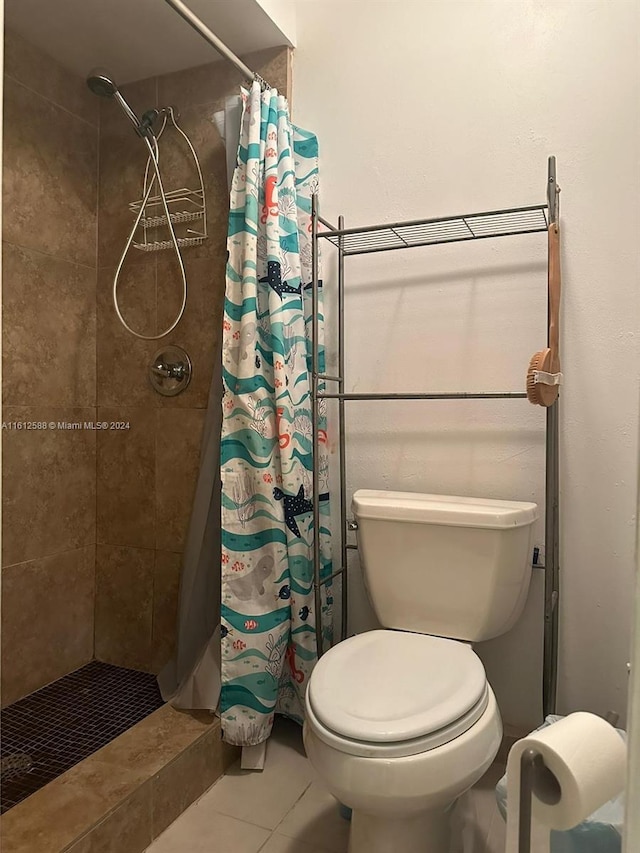 bathroom with a shower with shower curtain, tile patterned floors, and toilet