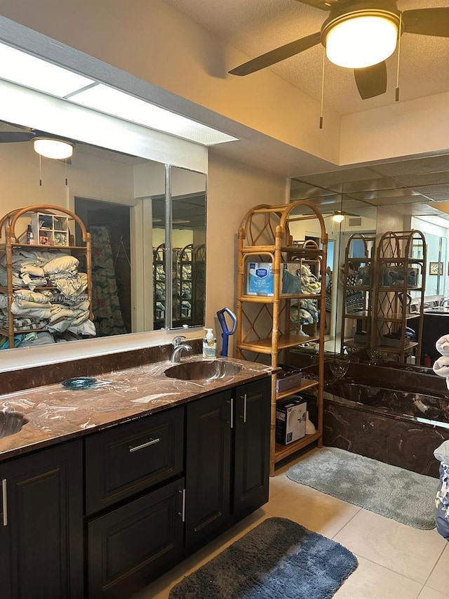 bathroom featuring tile patterned floors, ceiling fan, vanity, and a textured ceiling