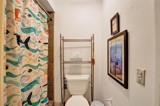 bathroom featuring a shower with curtain and toilet