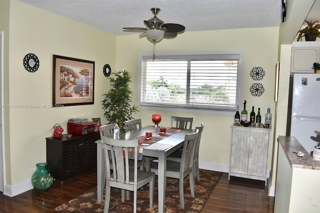 dining area featuring dark wood-type flooring, a textured ceiling, and ceiling fan