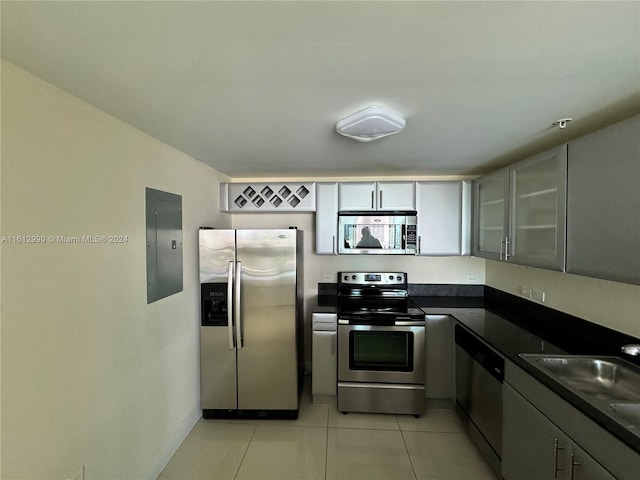 kitchen featuring gray cabinetry, stainless steel appliances, light tile flooring, and sink