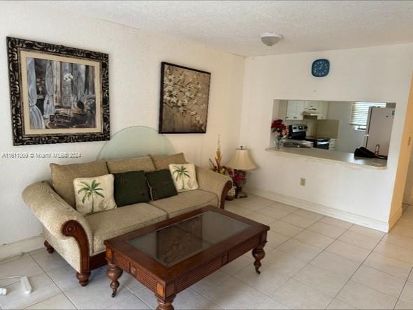 tiled living room featuring a textured ceiling