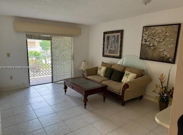 tiled living room featuring a textured ceiling