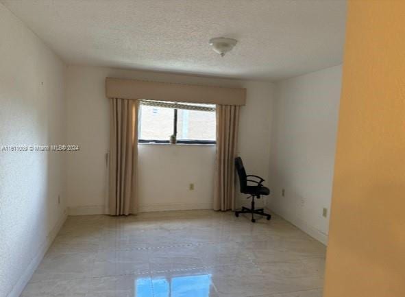 unfurnished room with a textured ceiling