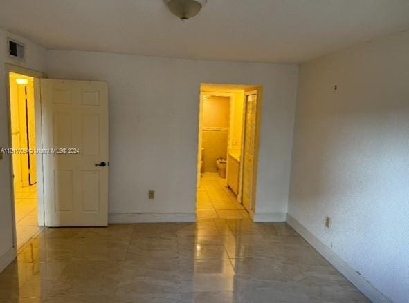 unfurnished room with visible vents and baseboards