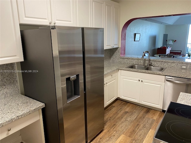 kitchen with white cabinets, wood finished floors, appliances with stainless steel finishes, and a sink