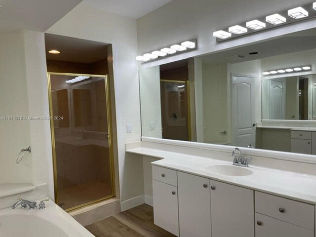 bathroom featuring vanity, hardwood / wood-style flooring, and walk in shower