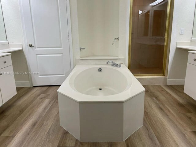 bathroom with vanity, hardwood / wood-style floors, and independent shower and bath