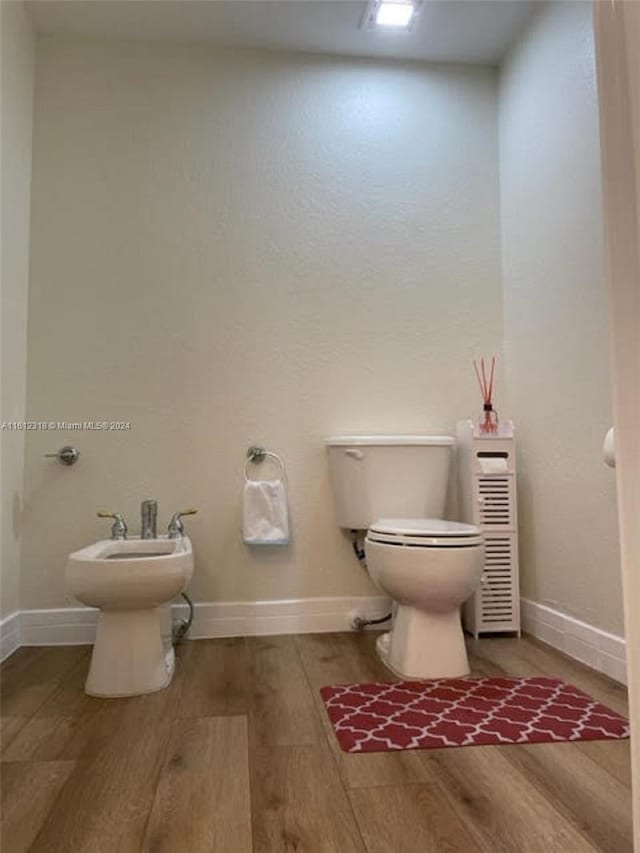 bathroom featuring a bidet, toilet, and hardwood / wood-style floors