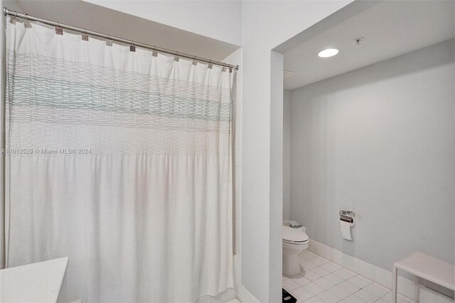 bathroom featuring tile patterned flooring, toilet, and walk in shower