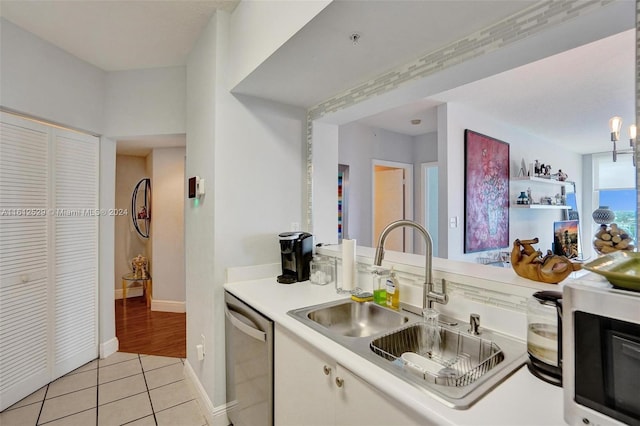 kitchen with dishwasher, light tile patterned floors, and sink