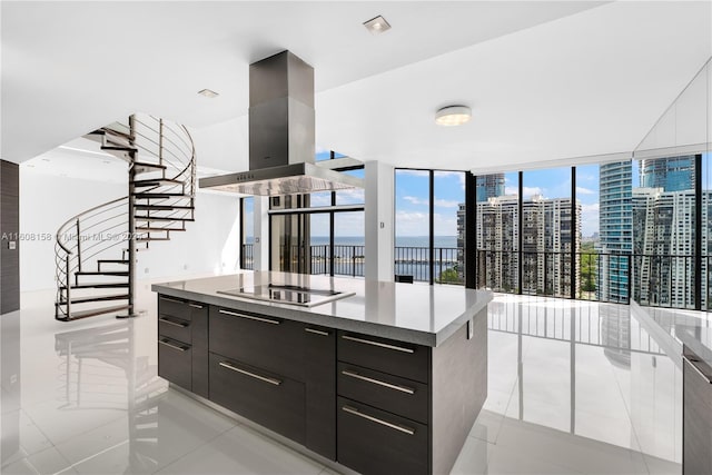 kitchen with a center island, black electric stovetop, expansive windows, light tile patterned floors, and island range hood