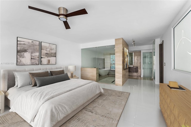 tiled bedroom featuring ensuite bathroom and ceiling fan