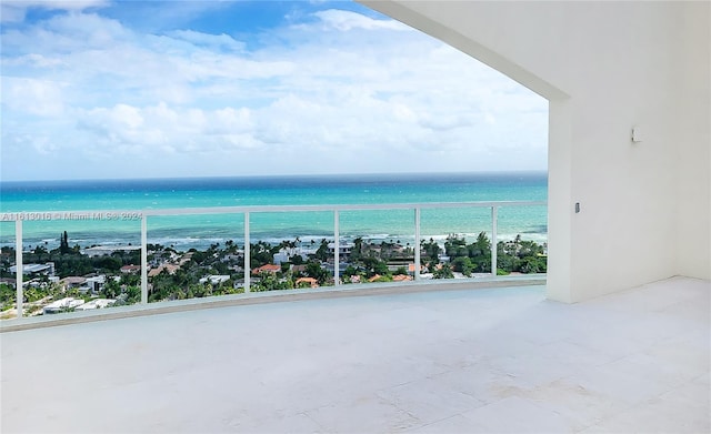 balcony featuring a view of the beach and a water view