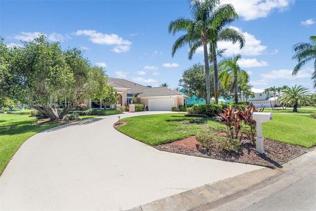 view of front of house featuring a garage and a front lawn