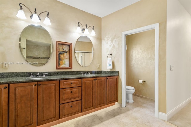 bathroom with double vanity, toilet, and tile floors