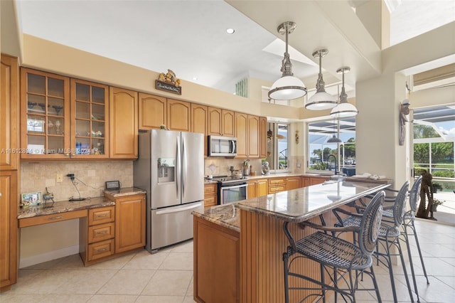 kitchen with appliances with stainless steel finishes, a healthy amount of sunlight, tasteful backsplash, and dark stone countertops