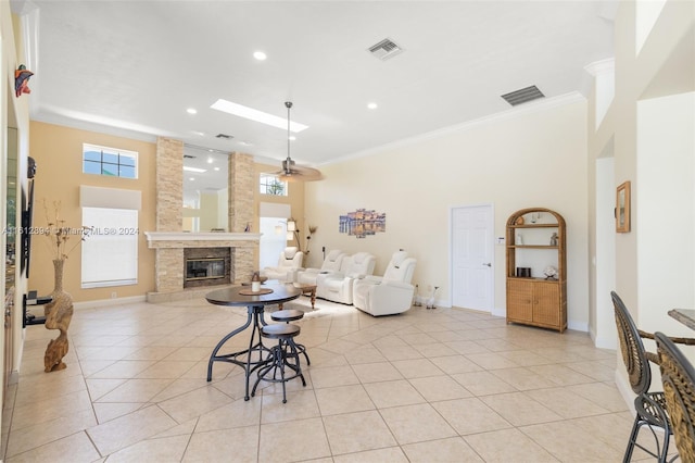 living room with crown molding, a fireplace, plenty of natural light, and ceiling fan