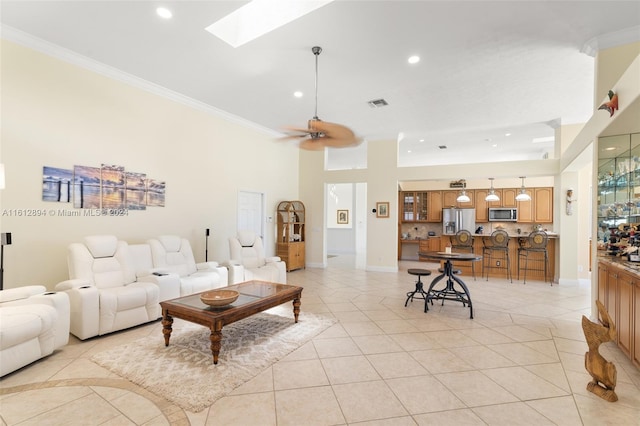 tiled living room with crown molding, ceiling fan, and a skylight