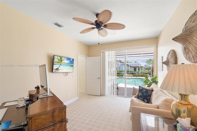 living area with light colored carpet and ceiling fan