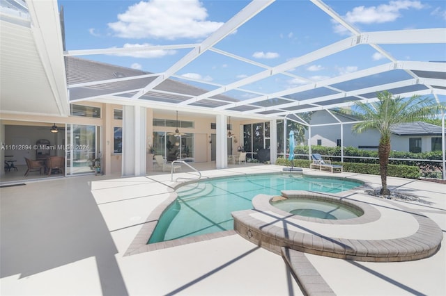 view of swimming pool featuring an in ground hot tub, a patio, and a lanai