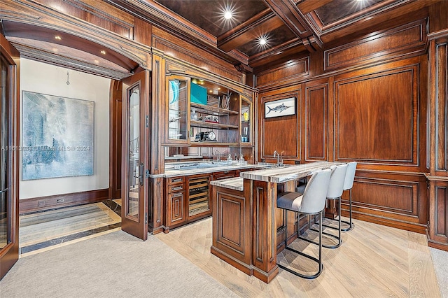 home office featuring wood walls, coffered ceiling, crown molding, beam ceiling, and light colored carpet