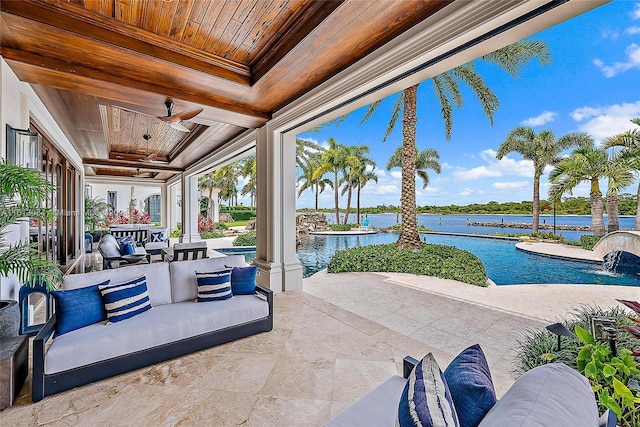 view of patio / terrace featuring pool water feature, a water view, an outdoor living space, and ceiling fan