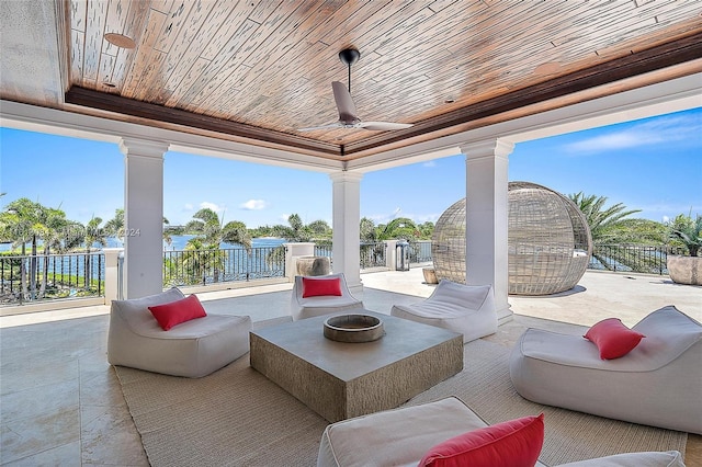 view of patio featuring ceiling fan, a water view, and an outdoor living space