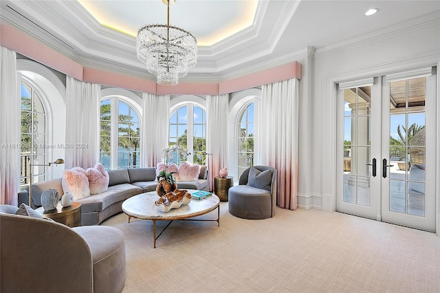 sunroom featuring a tray ceiling, french doors, and a chandelier