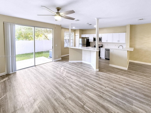 kitchen featuring ceiling fan, sink, appliances with stainless steel finishes, white cabinets, and light wood-type flooring