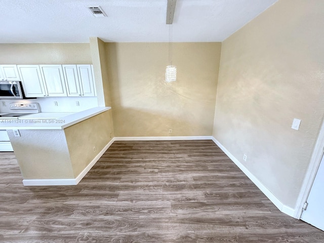 kitchen with electric range, dark hardwood / wood-style flooring, kitchen peninsula, and hanging light fixtures