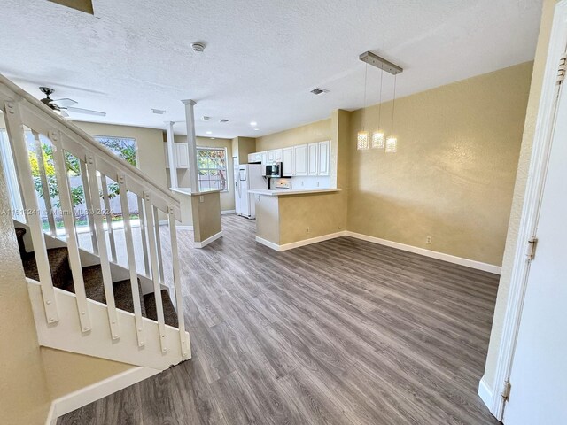 staircase with hardwood / wood-style floors, ceiling fan, and a textured ceiling