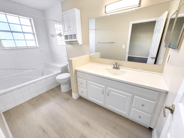 full bathroom featuring wood-type flooring, vanity, toilet, and tiled shower / bath combo