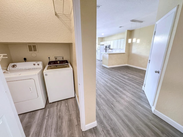 laundry area featuring hardwood / wood-style floors and washer and clothes dryer